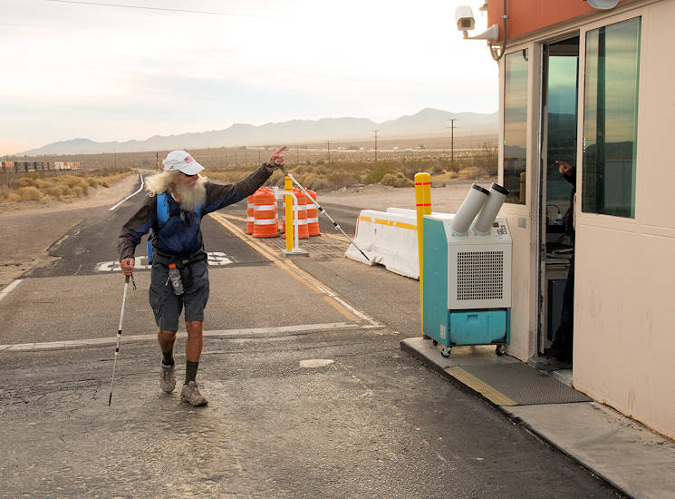 Meredith J. “Sunny” Eberhart, waves hello to a Marine Corps police officer as he walks through the back gate of Marine Corps Logistics Base Barstow, California around 7 a.m. on November 15, 2017. Eberhart began walking the entire length of Route 66 in Chicago 112 days ago and plans to finish in Santa Monica, Calif., in nine more days. (U.S. Marine Corps photo by Keith Hayes)