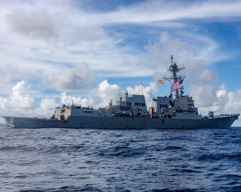 April 29, 2025 - The Arleigh Burke-class guided-missile destroyer USS Ralph Johnson (DDG 114) holds station off the coast of U.S. Navy Support Facility (NSF) Diego Garcia located on the atoll Diego Garcia in the Indian Ocean. Ralph Johnson is forward deployed and assigned to Destroyer Squadron (DESRON) 15, the Navy’s largest DESRON and the U.S. 7th fleet’s principal surface force. (Image created by USA Patriotism! from U.S. Navy photo by MC1 Hannah Fry.)