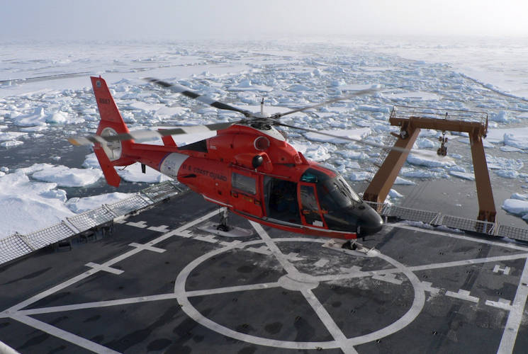 August 24, 2005 – A U.S. Coast Guard HH-65 Dolphin helicopter prepares to depart the Coast Guard cutter USCGC Healy (WAGB 20) to fly members of a science party to a remote ice floe to collect ice samples and data about Arctic sea ice. (U.S. Navy photo by Aerographer’s Mate 1st Class Gene Swope)