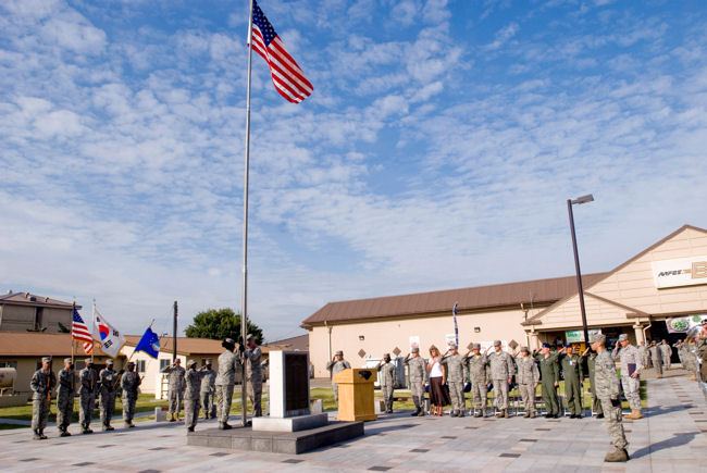 Servicemembers and guests salute the U.S. flag during the September 11 Patriot Day Ceremony Sept. 11, 2009, at Kunsan Air Base, Republic of Korea. The ceremony acknowledged the courageous firefighters, police officers, emergency responders and others who risked their lives to save the victims of the tragic events of Sept. 11, 2001. The ceremony also paid tribute to the men and women of the U.S. Armed Forces who have served in the military, whether deployed or at home station, since these events.