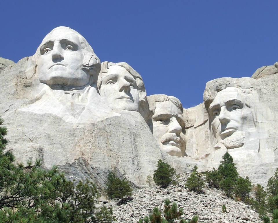 A close-up view of Mount Rushmore with the majestic figures of George Washington, Thomas Jefferson, Theodore Roosevelt and Abraham Lincoln. Mount Rushmore, surrounded by the beauty of the Black Hills of South Dakota, represents the story of the birth, growth, development and preservation of our beloved USA. Mount Rushmore brings nearly three million visitors each year face to face with the rich heritage that we all share. (Image created by USA Patriotism! from U.S. National Park Service photo.)